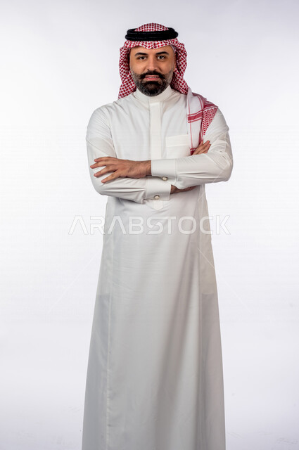 بورتريه بصورة مقربة لرجل سعودي خليجي يقوم بجلسة تصوير بإيدي متقاطعة بإيماءات وجه ويدين مختلفة ، خلفية بيضاء لرجل سعودي يرتدي زي تقليدي سعودي مع شماغ وعقال