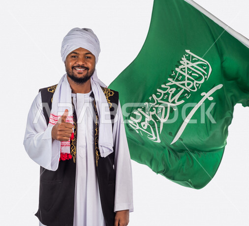 بورتريه لرجل عربي سوداني مبتسم ، خلفه علم المملكة العربية السعودية، ذكرى اليوم الوطني السعودي، الاحتفال بالعيد الوطني السعودي ، خلفية بيضاء لرجل سوداني مسلم يرتدي الزي السوداني مع العمه الملفحة