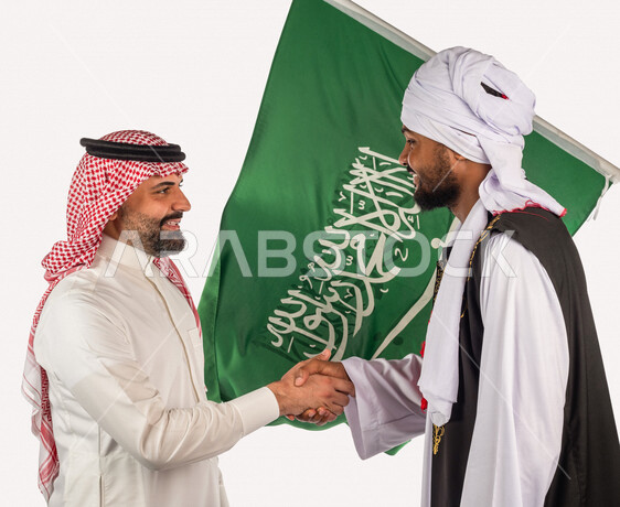 بورتريه لرجل عربي سعودي خليجي يرتدي زي تقليدي سعودي مبتسم يصافح رجل سوداني يرتدي الزي السوداني بإيماءات الوجه واليدين، علم السعودية مصورة على خلفية بيضاء، ذكرى اليوم الوطني السعودي، الاحتفال بالعيد الوطني السعودي