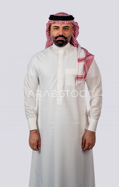 بورتريه لرجل سعودي خليجي مبتسم يقوم بجلسة تصوير ينظر إلى الكاميرا بإيماءات وجه ويدين مختلفة ، خلفية بيضاء لرجل سعودي مسلم يرتدي زي تقليدي سعودي مع شماغ وعقال