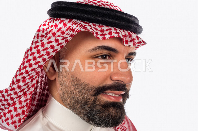 بورتريه بصورة مقربة لرجل سعودي خليجي يقوم بجلسة تصوير بإيماءات وجه ويدين مختلفة ، منظر جانبي لرجل سعودي يرتدي زي تقليدي سعودي مع شماغ وعقال ، خلفية بيضاء
