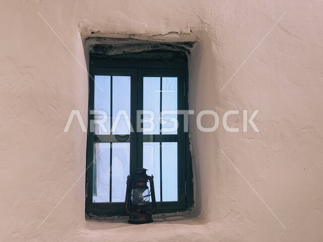 Traditional heritage mud houses in the old town of AlUla, the authentic Arab civilization and heritage, a close-up of a decorated metal lantern in front of the black window of a house in the Kingdom, popular coastal areas in Saudi Arabia