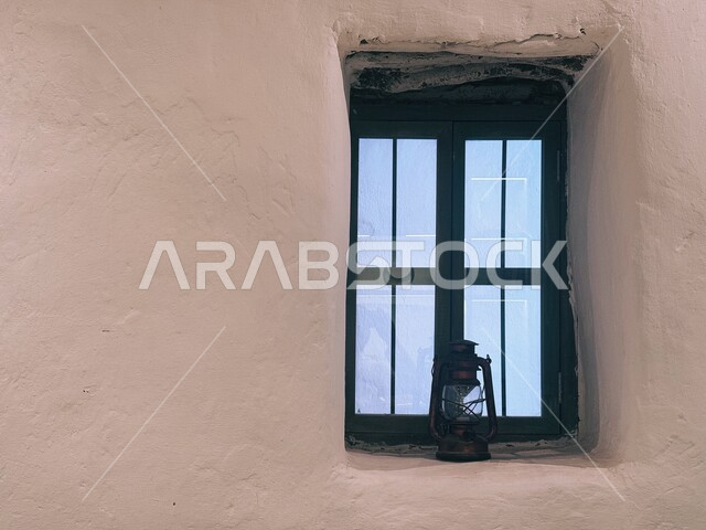 البيوت والمنازل الطينية  التراثية التقليدية في بلدة العلا القديمة، العراقة والحضارة العربية الأصلية، صورة مقربة لفانوس معدني مزخرف أمام النافذة السوداء لمنزل في المملكة، المناطق الساحية الشعبية في السعودية