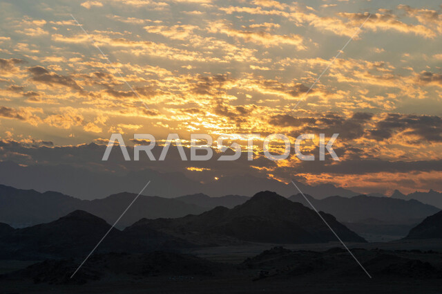 التضاريس و المرتفعات والقمم الجبلية في البراري، مناطق البادية والبيئة الطبيعية، التكوينات والتشكلات الصخرية في صحراء المملكة العربية السعودية، سماء مليئة بالغيوم وقت غروب الشمس