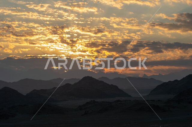 التضاريس و المرتفعات والقمم الجبلية في البراري، مناطق البادية والبيئة الطبيعية، التكوينات والتشكلات الصخرية في صحراء المملكة العربية السعودية، سماء مليئة بالغيوم وقت غروب الشمس