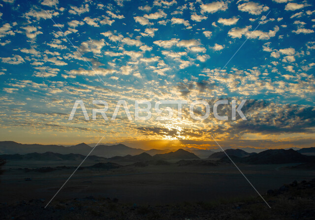 Desert areas and natural environment, rock formations and formations in the desert of the Kingdom of Saudi Arabia, terrain, heights and mountain peaks in the wilderness, a sky full of clouds at sunset