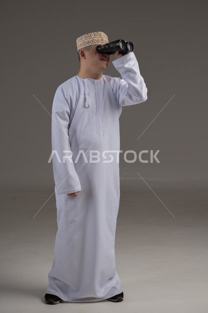 تقديم الحب و الرعاية، الاهتمام ودعم المجتمع العماني لذوي الاحتياجات الخاصة ، بورتريه لرجل عربي خليجي يرتدي الزي التقليدي يحمل بيده منظار وينظر لشيء ما, 
