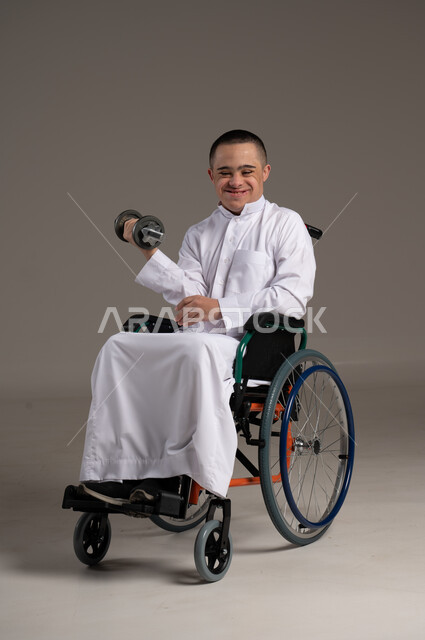 إيماءات وجه ويد تدل على السعادة، بورتريه لشاب عربي سعودي خليجي يرتدي الثوب التقليدي يحمل بيده دمبلز,التمكين الاجتماعي للمعاقين, اهتمام ودعم المجتمع السعودي لذوي الاحتياجات الخاصه, تقديم الحب و الرعاية
