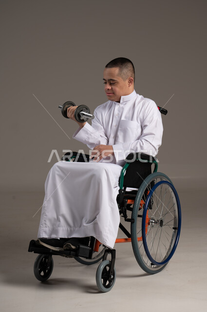 إيماءات وجه ويد تدل على السعادة، بورتريه لشاب عربي سعودي خليجي يرتدي الثوب التقليدي يحمل بيده دمبلز,التمكين الاجتماعي للمعاقين, اهتمام ودعم المجتمع السعودي لذوي الاحتياجات الخاصه, تقديم الحب و الرعاية