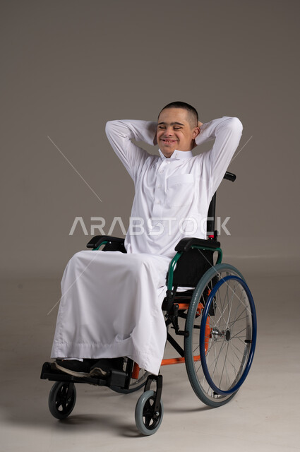 إيماءات وجه ويد تدل على السعادة ,التمكين الاجتماعي للمعاقين, بورترية لشاب عربي خليجي يرفع يديه خلف رأسه وينظر الى الكاميرا ، اهتمام ودعم المجتمع السعودي لذوي الاحتياجات الخاصه, تقديم الحب و الرعاية