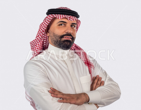 بورتريه بصورة مقربة لرجل سعودي خليجي يقوم بجلسة تصوير بإيدي متقاطعة بإيماءات وجه ويدين مختلفة ، منظر جانبي لرجل سعودي يرتدي زي تقليدي سعودي مع شماغ وعقال ، خلفية بيضاء