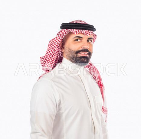 بورتريه بصورة مقربة لرجل سعودي خليجي يقوم بجلسة تصوير بإيماءات وجه ويدين مختلفة ، منظر جانبي لرجل سعودي يرتدي زي تقليدي سعودي مع شماغ وعقال ، خلفية بيضاء