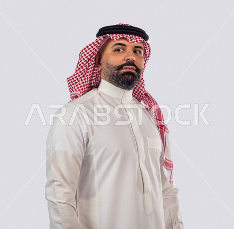 بورتريه بصورة مقربة لرجل سعودي خليجي يقوم بجلسة تصوير بإيماءات وجه ويدين مختلفة ، منظر جانبي لرجل سعودي يرتدي زي تقليدي سعودي مع شماغ وعقال ، خلفية بيضاء