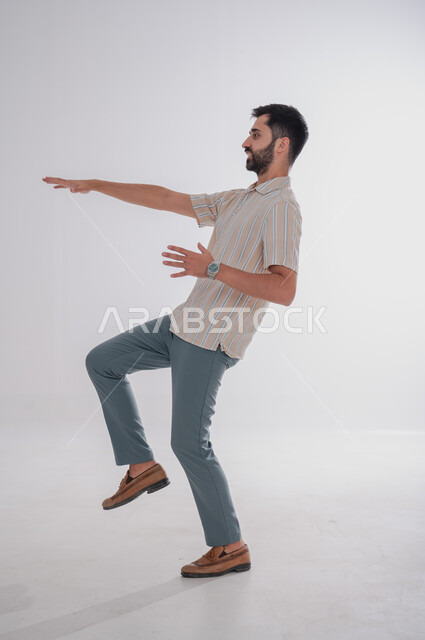 ايماءات تفادي شيء ما، مفهوم السقوط او الانزلاق, بورتريه لرجل عربي خليجي سعودي من الجانب يحاول تجنب حدث ما، الجسم بالطول الكامل, خلفية بيضاء