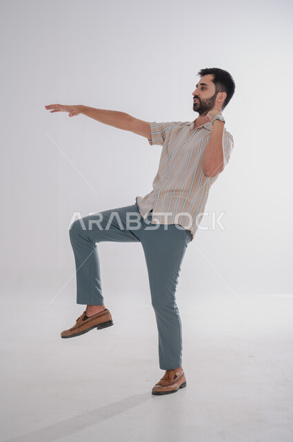 ايماءات تفادي شيء ما، مفهوم السقوط او الانزلاق, بورتريه لرجل عربي خليجي سعودي من الجانب يحاول تجنب حدث ما، الجسم بالطول الكامل, خلفية بيضاء