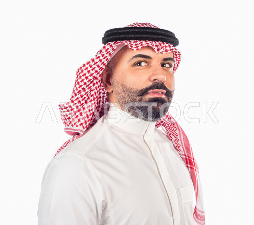بورتريه بصورة مقربة لرجل سعودي خليجي يقوم بجلسة تصوير بإيماءات وجه ويدين مختلفة ، منظر جانبي لرجل سعودي يرتدي زي تقليدي سعودي مع شماغ وعقال ، خلفية بيضاء