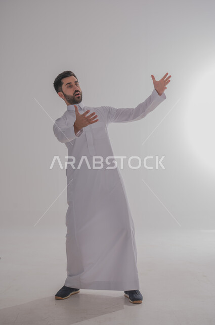 تعابير تفادي او الابتعاد عن شيء ما، بورتريه لرجل عربي خليجي يرتدي الثوب، الوقوف ورفع اليدين بايماءات الصدمة, الجسم بالطول الكامل, خلفية بيضاء