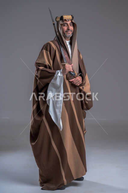 إحياء تاريخ الأجداد والاحتفال بإنجازاتهم، ذكرى تأسيس المملكة 1727, بورتريه لرجل عربي خليجي سعودي يرتدي البشت والغترة يحمل البندقية بفخر وينظر الى الكاميرا، ارتداء الأزياء الشعبية الوطنية، الاحتفال بيوم التأسيس 22 فبراير, اهتمام أبناء المملكة بهواية صيد الصقور