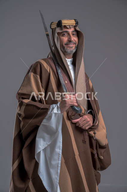 إحياء تاريخ الأجداد والاحتفال بإنجازاتهم، ذكرى تأسيس المملكة 1727, بورتريه لرجل عربي خليجي سعودي يرتدي البشت والغترة يحمل البندقية بفخر وينظر الى الكاميرا، ارتداء الأزياء الشعبية الوطنية، الاحتفال بيوم التأسيس 22 فبراير, اهتمام أبناء المملكة بهواية صيد الصقور