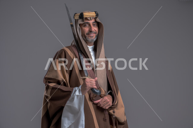 إحياء تاريخ الأجداد والاحتفال بإنجازاتهم، ذكرى تأسيس المملكة 1727, بورتريه لرجل عربي خليجي سعودي يرتدي البشت والغترة يحمل البندقية بفخر وينظر الى الكاميرا، ارتداء الأزياء الشعبية الوطنية، الاحتفال بيوم التأسيس 22 فبراير, اهتمام أبناء المملكة بهواية صيد الصقور