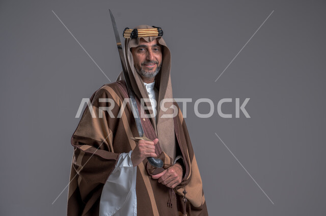 إحياء تاريخ الأجداد والاحتفال بإنجازاتهم، ذكرى تأسيس المملكة 1727, بورتريه لرجل عربي خليجي سعودي يرتدي البشت والغترة يحمل البندقية بفخر وينظر الى الكاميرا، ارتداء الأزياء الشعبية الوطنية، الاحتفال بيوم التأسيس 22 فبراير, اهتمام أبناء المملكة بهواية صيد الصقور