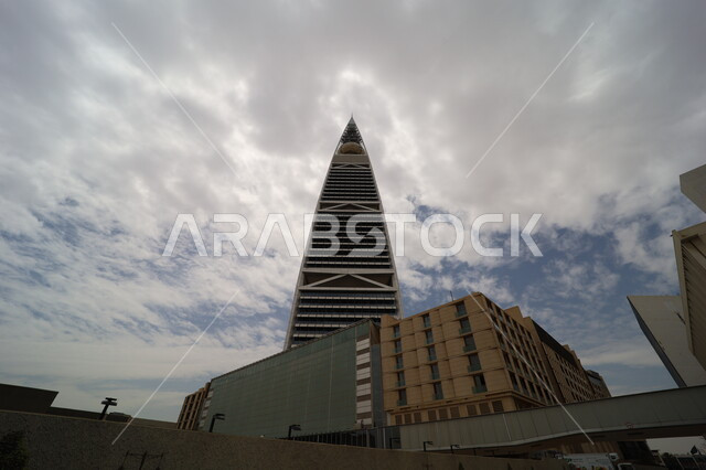 معالم ومباني مشهورة، منظر السماء المليئة بالغيوم البيضاء، النمو والتطور العمراني في العاصمة، صورة من الاسفل لبرج الفيصلية في مدينة الرياض، الفن الهندسي المعماري للأبراج وناطحات السحاب في المملكة العربية السعودية