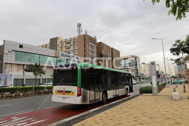 وسائل المواصلات السريعة، التصميم الهندسي المعماري للطرق بالعاصمة، حركة مرور السيارات في الشوارع الرئيسية، باص النقل الجماعي في الموقف الترددي نهارا، خط سير الحافلات، السماء المليئة بالغيوم البيضاء