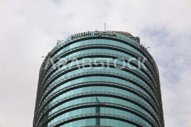 التقدم والتطور في عمارة المباني، السماء المليئة بالغيوم البيضاء، أماكن جذب الزوار من أنحاء العالم، صورة مقربة لفندق هيلتون في مدينة الرياض، الفن الهندسي المعماري للأبراج وناطحات السحاب على الطراز الحديث، المعالم السياحية المشهورة في السعوديه