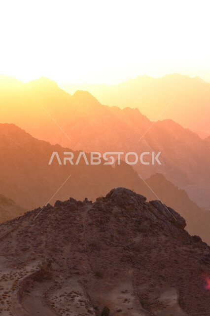 منظر غروب الشمس البرتقالي فوق سلسلة جبال الفقرة، المعالم والأماكن السياحية، المناظر الطبيعية المتميزة في المملكة العربية السعودية، الجبال الصخرية على طريق المدينة المنورة، القمم والمرتفعات الجبلية
