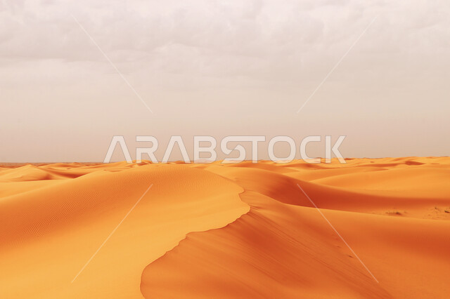 الغيوم البيضاء المتكاثفة في سماء المملكة العربية السعودية، الهضاب والتلال من الرمال الناعمة الذهبية، مناطق البادية وبيئة الطبيعية الصحراوية، الكثبان الرملية في الصحراء العربية الكبرى 