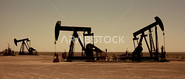 حفارات تقوم بالتنقيب عن النفط وسط الكثبان الرملية في المناطق الصحراوية, آلات حفر ضخمة, استخراج وتصدير الثروات الباطنية، جودة الأدوات والمعدات الصناعة، مراكز تخزين البترول في صحارى المملكة العربية السعودية، منصة نفط لاستنباط الزيوت وقت غروب الشمس