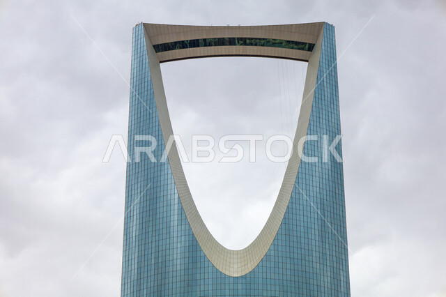 Modern and advanced design of towers and skyscrapers in Saudi Arabia, famous tourist places, architectural art of commercial facilities in Riyadh, close-up of Kingdom Tower building in daytime, view of sky filled with clouds