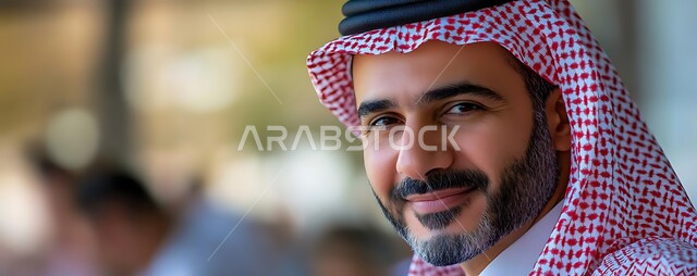 الاهتمام بالأناقة والمظهر الخارجي، صورة مقربة لرجل عربي خليجي سعودي مبتسم يرتدي الشماغ والثوب التقليدي ينظر إلى الكاميرا بإيماءات السرور، الشعور بالثقة في النفس