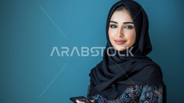 مفهوم الأنوثة والنعومة، أزياء محجبات عصرية حديثة، الاهتمام بالأناقة والجمال والمظهر الخارجي, بورتريه لامرأة خليجية سعودية عربية محجبة تنظر إلى الكاميرا بحركات تدل على الثقة بالنفس والمتعة