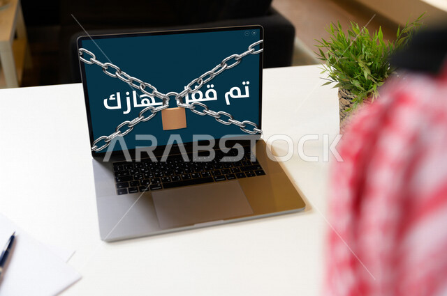 رجل أعمال عربي سعودي خليجي يستخدم جهاز الحاسوب بمستوى أمن وحماية عالي ، حماية المعلومات الشخصية ، أنطمة التكنلوجيا الفائقة ، مفهوم خصوصية بيانات المستخدم لحماية بيانات الأمن السيبراني