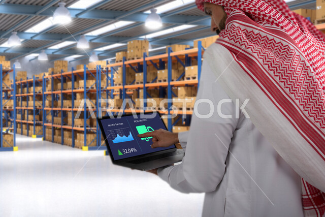 نظام ادارة المستودعات الذكي، صورة مقربة لمشرف اداري عربي سعودي خليجي ينظم ادارة المخازن عن طريق جهاز الابتوب المحمول، الإشراف على المستودعات و المخازن من خلال انظمة ذكية، الإشراف على عمليات الاستلام والتخزين والتوزيع والصيانة باستخدام تقنيات متطورة