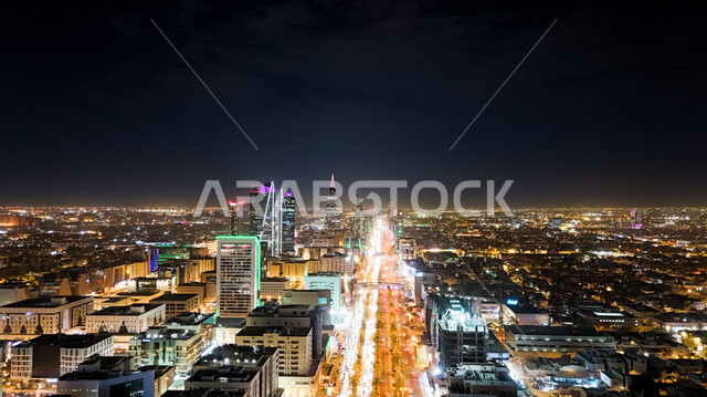 النمو والتطور العمراني في المملكة العربية السعودية، صورة من طائرة درون للفن الهندسي المعماري لمدينة الرياض في وقت الليل، الأبراج وناطحات السحاب والمنشآت والمباني التجارية، التقدم الحضاري في المدن والأحياء، برج المملكة الشامخ المضيء ليلا، أماكن سياحية مشهورة