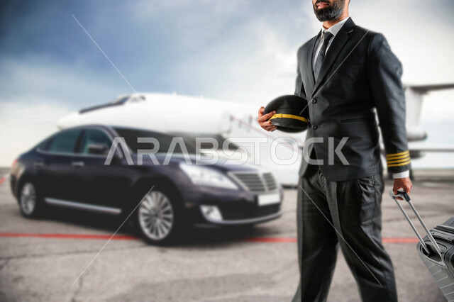 كابتن طيار عربي سعودي خليجي ناجح ، يعمل في مجال الطيران ، يرتدي الزي الرسمي الخاص بمزاولة مهنة الطيران ، الإستعداد لرحلة طيران جوية