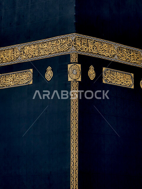 صورة مقربة لكسوة الكعبة المشرفة مغطاة بقماش من  الحرير الأسود مزينة بنقوش و زخارف من خيوط دهبية اسلامية و نصوص قرآنية ،المسجد الحرام في مكة المكرمة ، المملكة العربية السعودية  