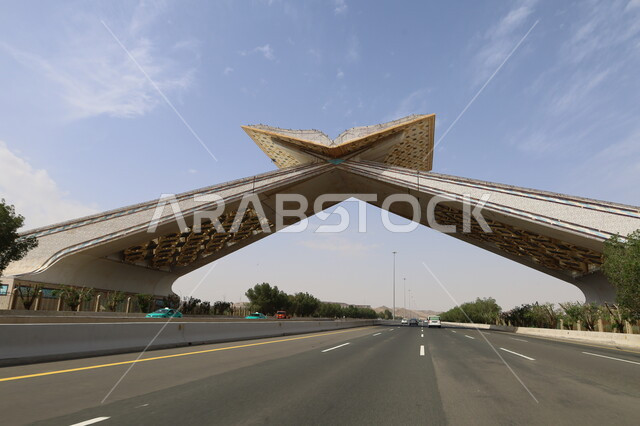 Travel and transportation on the highway between Jeddah and Mecca, a model of the Quran Gate in the shape of the Holy Quran on the highway, famous holy religious places, traffic movement on paved roads and streets in the Kingdom of Saudi Arabia