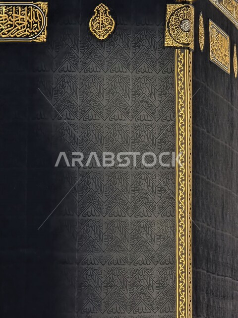 صورة مقربة لكسوة الكعبة المشرفة مغطاة بقماش من  الحرير الأسود مزينة بنقوش و زخارف من خيوط دهبية اسلامية و نصوص قرآنية ،المسجد الحرام في مكة المكرمة ، المملكة العربية السعودية 