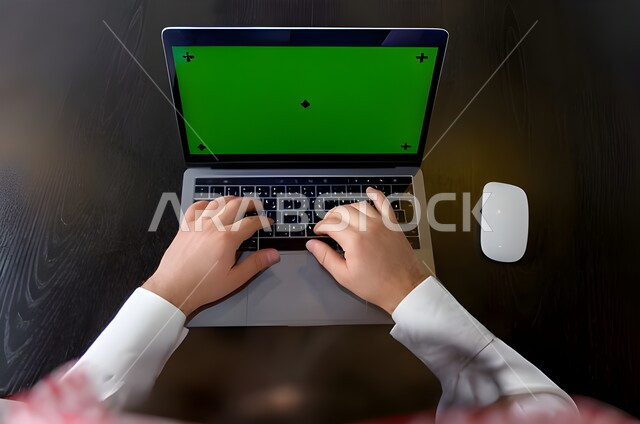 مشاهدة الأفلام والمسلسلات، استخدام الكمبيوتر المكتبي بخلفية خضراء كروما، الدردشة والمحادثات والتواصل الاجتماعي , التسويق لموقع إلكتروني، صورة من الاعلى لرجل عربي خليجي اماراتي يرتدي الزي التقليدي