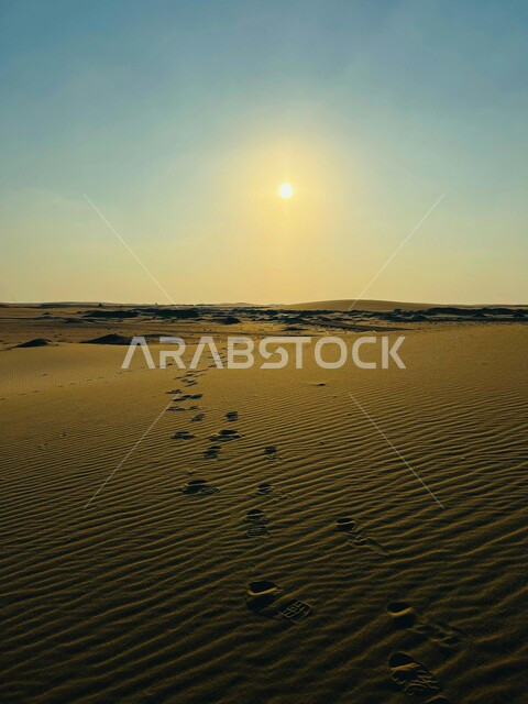 آثار مسير أقدام على الكثبان الرملية، الرمال الذهبية الناعمة و التضاريس الصحراوية في المملكة العربية السعودية, أماكن السياحة ورحلات السفاري والأنشطة الترفيهية، صحراء شبه الجزيرة العربية، منظر الشمس وسط السماء الصافية، خلفية الطبيعة