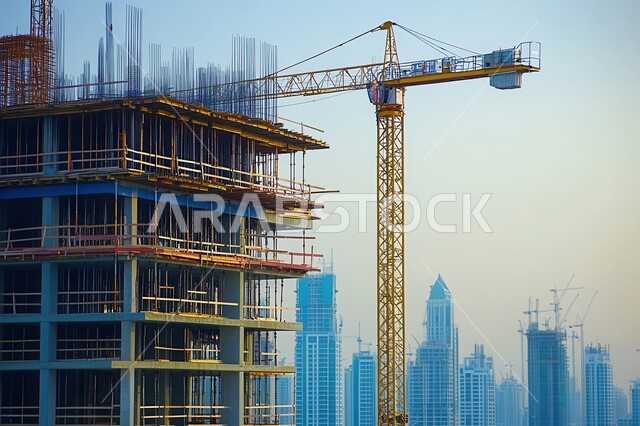مفهوم الهندسة الانشائية والمعمارية, مبنى قيد الانشاء في المملكة العربية السعودية, أعمال البناء وصب الخرسانات ووضع الأساسات, تنفيذ مخطط الإعمار وتشكيل الهيكل المعدني، برج تحت التشييد باستخدام الآليات الحديثة، الآلات والمعدات الثقيلة والرافعات والسقالات العالية