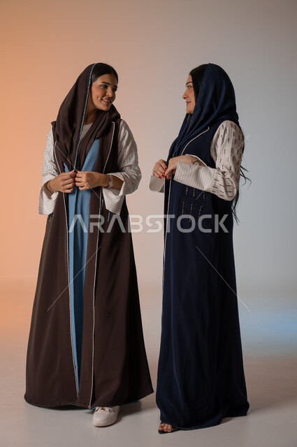  ايماءات الثقة والوقوف أمام الكاميرا، ارتداء العباءة الخليجية والنظارات الشمسية، الاحتراف في عرض آخر صيحات الموضة والجمال، بورتريه لعارضتان عربيتان سعوديتان خليجيتان، صورة الجسم بالطول الكامل، منتجات نسائيه سعوديه، شراء الأزياء والاكسسوارات, خلفية ملونة 