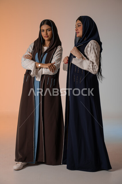  ايماءات الثقة والوقوف أمام الكاميرا، ارتداء العباءة الخليجية والنظارات الشمسية، الاحتراف في عرض آخر صيحات الموضة والجمال، بورتريه لعارضتان عربيتان سعوديتان خليجيتان، صورة الجسم بالطول الكامل، منتجات نسائيه سعوديه، شراء الأزياء والاكسسوارات, خلفية ملونة 