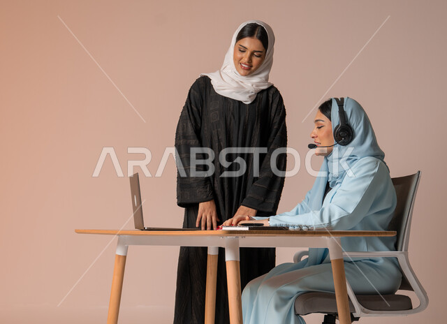  اداء المهام للتطور المهني وتحقيق الاهداف, الشراكة والتعاون في إنجاز المهام، بورتريه لسيدتان عربيتان خليجيتات سعوديتان محجبتان في اجتماع عمل، استخدام جهاز الحاسوب المحمول لمتابعة ومناقشة الأعمال، دراسة وتحليل المشاريع الجديدة، خلفية بيج