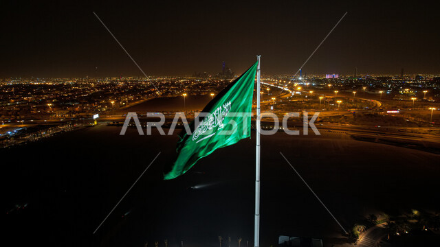 The flag of Saudi Arabia flutters in the night mode, the celebration of the Saudi National Day, the anniversary of the unification of the Kingdom of Saudi Arabia, the banner of monotheism and Islam