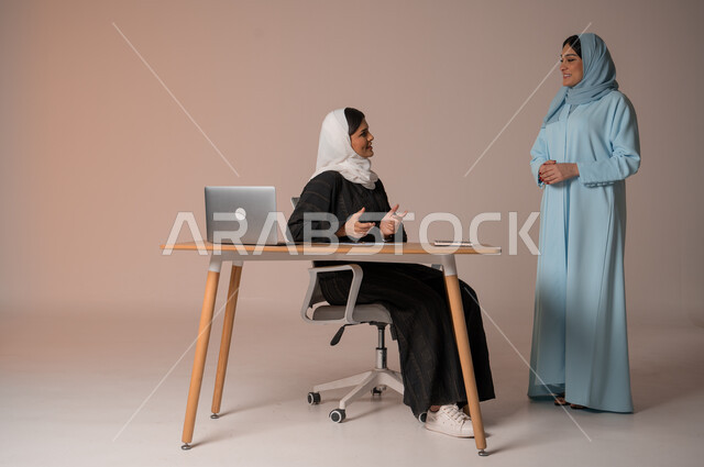 اداء المهام للتطور المهني وتحقيق الاهداف, الشراكة والتعاون في إنجاز المهام، بورتريه لسيداتان عربيتان خليجيتات سعوديتان يتناقشان في اجتماع عمل، العمل الجماعي وروح الفريق الواحد، دراسة وتحليل المشاريع الجديدة، جسم بالطول الكامل، خلفية بيج