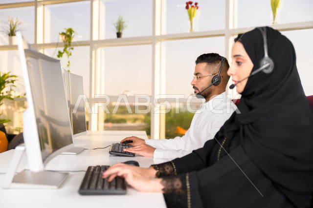 موظفان عربيان خليجيان سعوديان يعملان في خدمة العملاء، موظف وموظفة يرتديان سماعة الاتصال، استعلامات واستفسارات، الاجابه على اسئلة العملاء، اجراء اتصال فيديو من خلال الحاسوب، متابعة وتطوير العمل